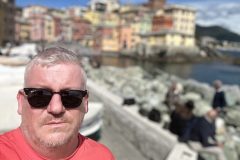 Portrait of Barrie Jarrett in Genoa Italy by the beach and rocks